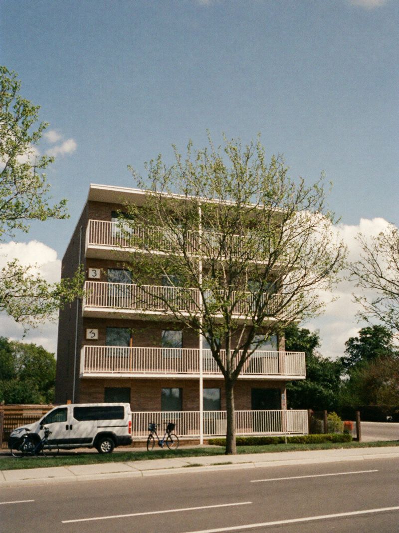 Modern brick apartment building with balconies on a quiet street